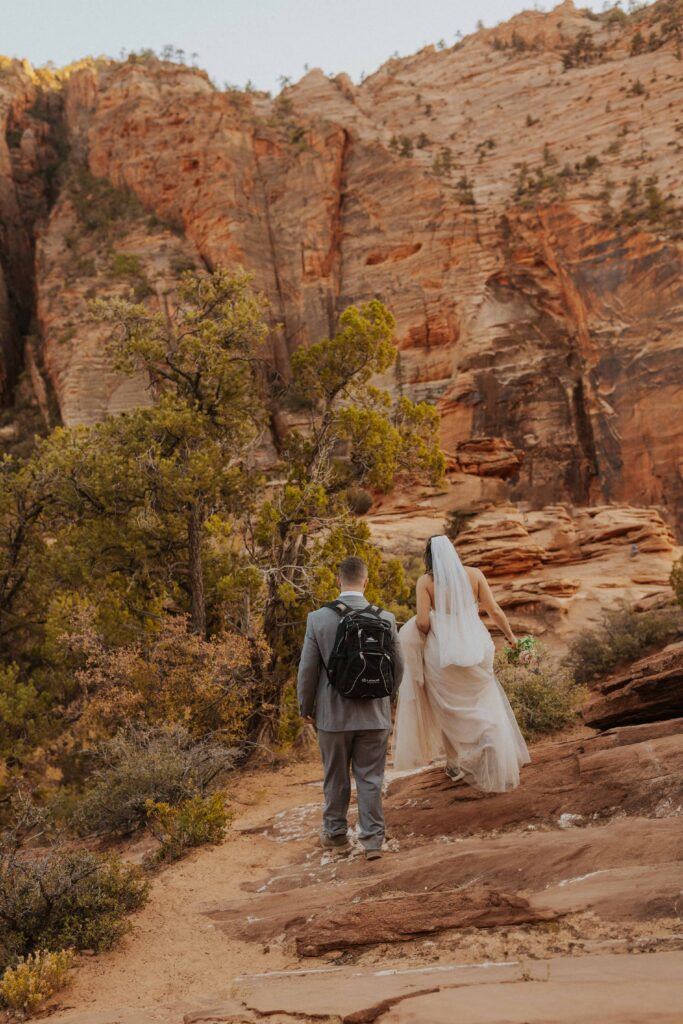 a bride and groom hiking around in Zion National Park