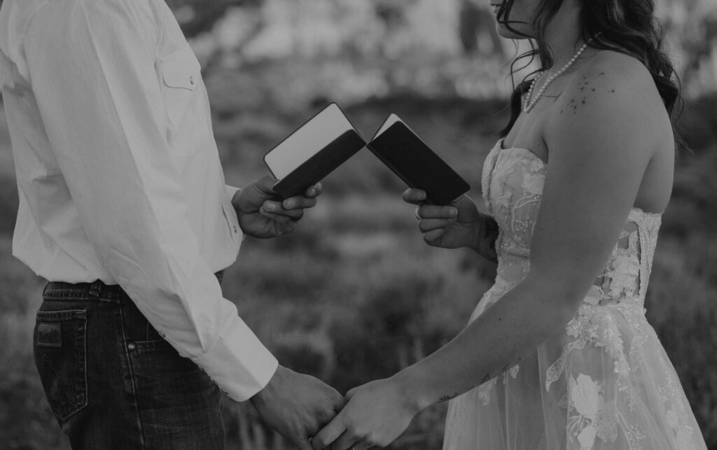 A bride and groom holding their vow books.