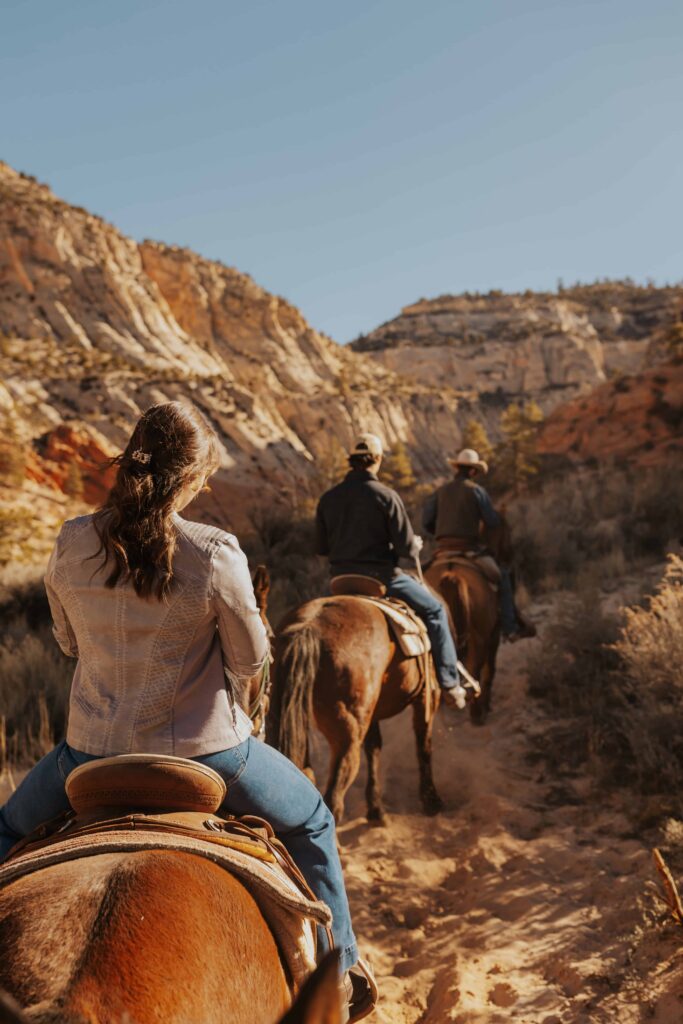 A couple horseback riding in a canyon