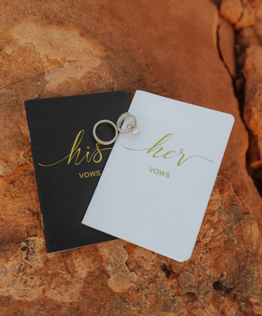 His and hers vow books sitting on a red rock backdrop