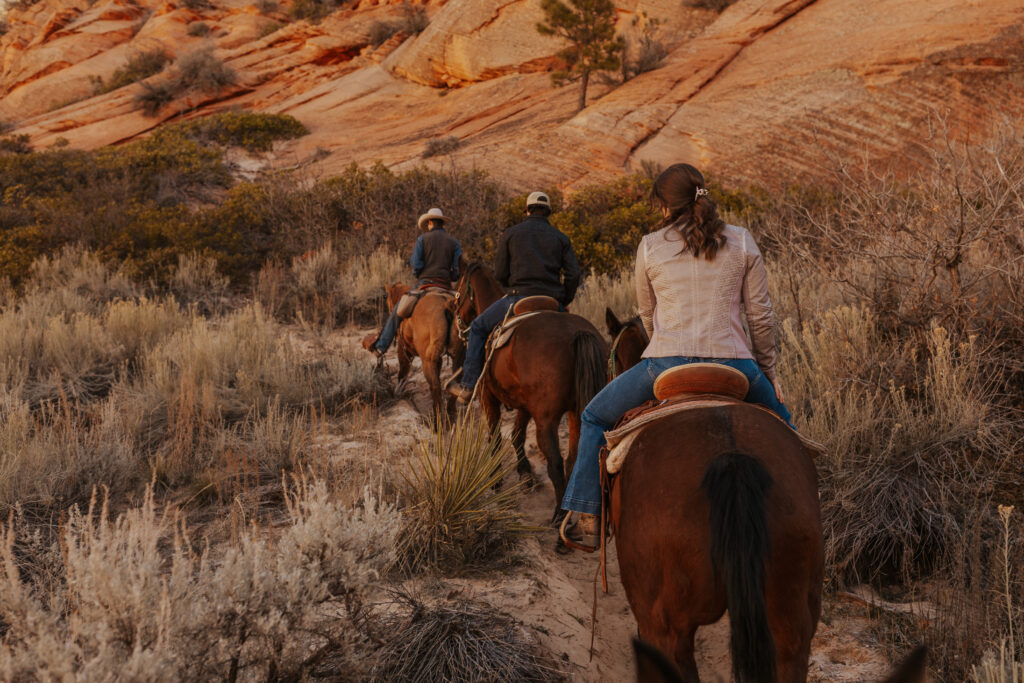 A couple horseback riding in Zion National Park during the fall season.