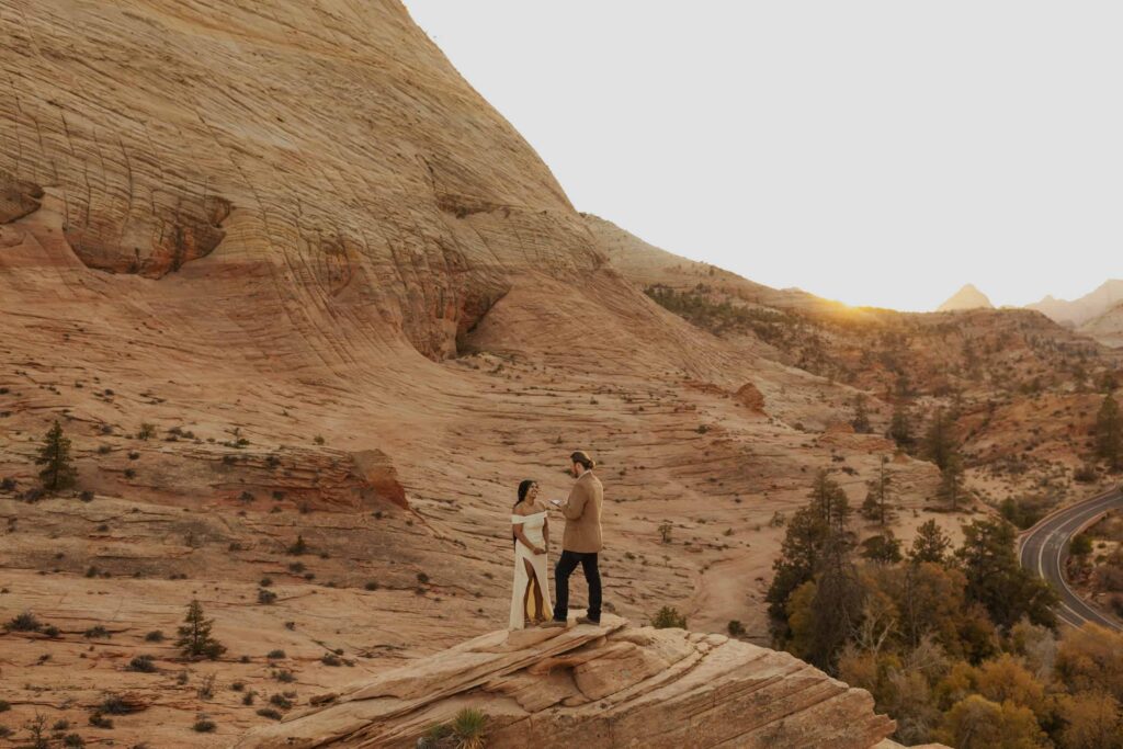A groom reading his vows to his new bride on an overlook in Zion National Park. 