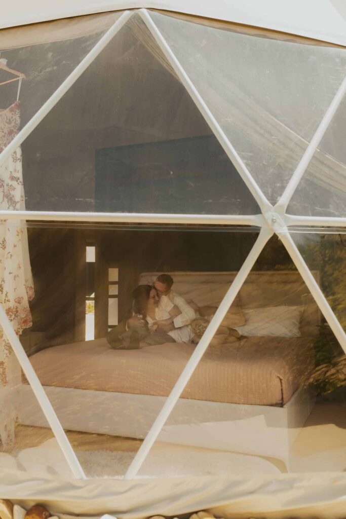 a couple cuddling in their dome Airbnb outside Bryce Canyon