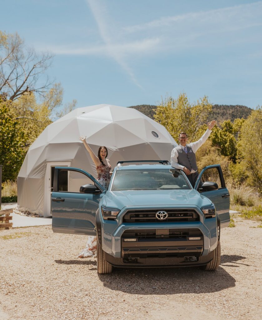 A couple standing outside their dome Airbnb