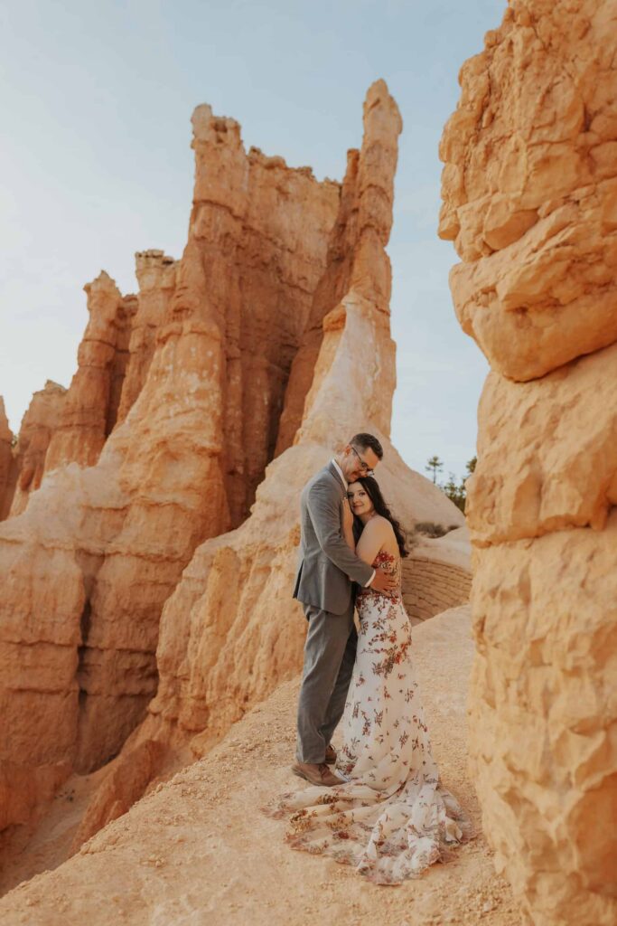 A bride and groom hugging next to some hoodoos in Bryce Canyon.