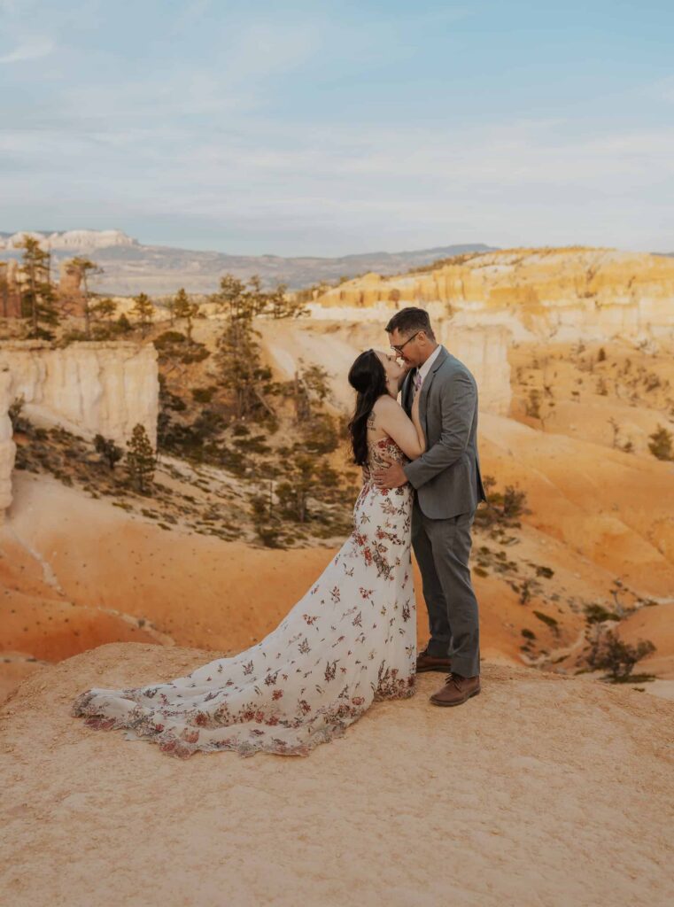 A bride and groom going in for a kiss overlooking Bryce Canyon National Park
